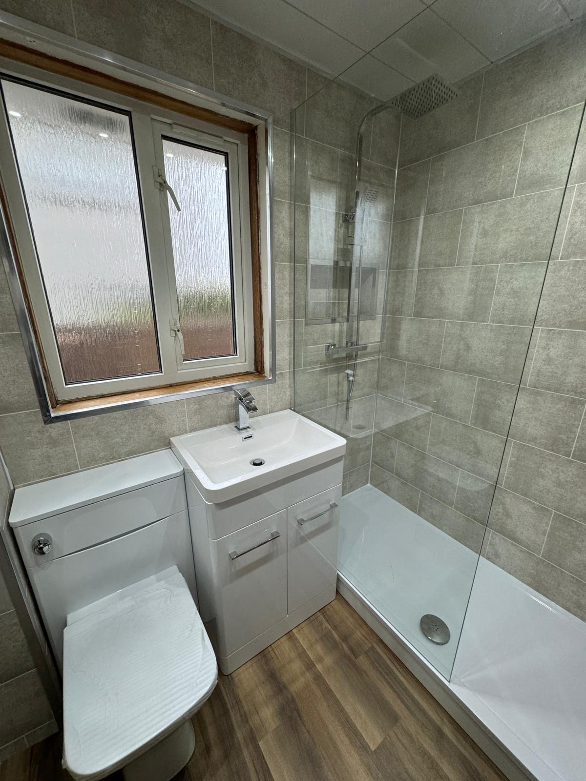 Compact walk-in shower room with grey stone tiling