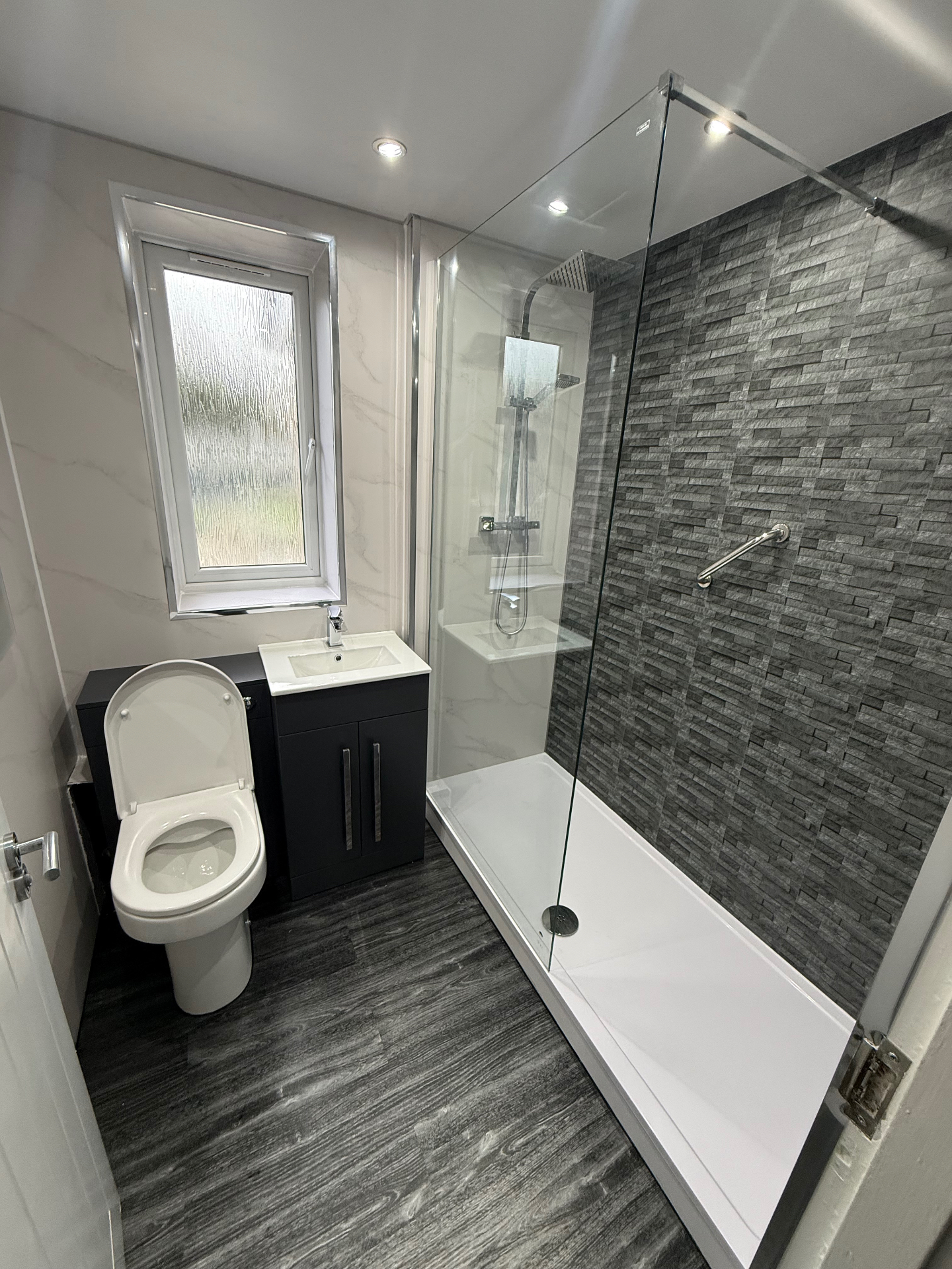 Monochrome bathroom with stacked stone feature wall
